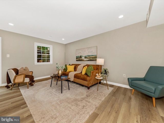 living room featuring baseboards, light wood-type flooring, and recessed lighting
