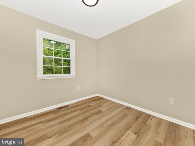 empty room with baseboards and wood finished floors