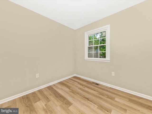 unfurnished room featuring baseboards and light wood-style floors