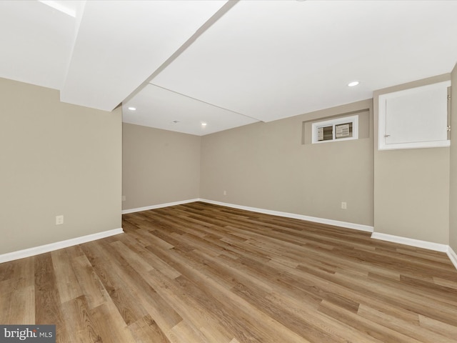 spare room with baseboards, light wood-style flooring, and recessed lighting