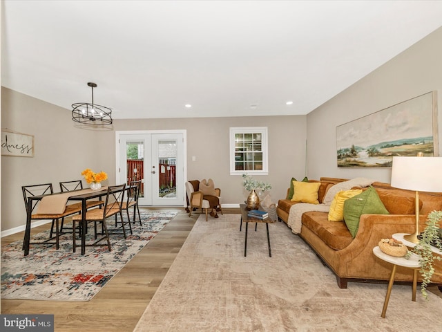 living room featuring a chandelier, wood finished floors, baseboards, french doors, and recessed lighting