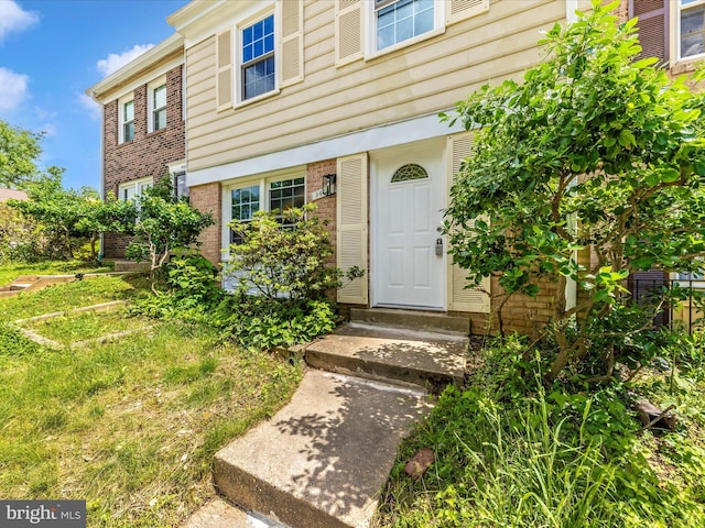 entrance to property featuring brick siding