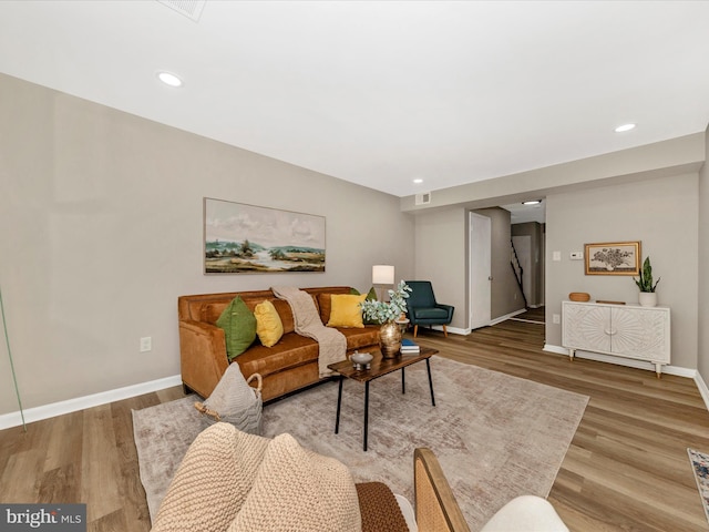 living area featuring baseboards, wood finished floors, and recessed lighting