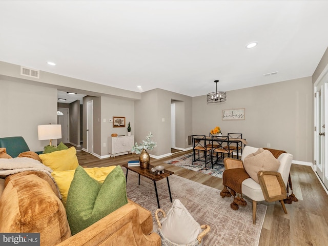 living room featuring wood finished floors, baseboards, a chandelier, and recessed lighting