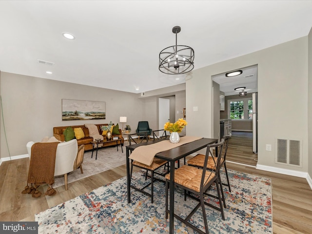 dining space featuring wood finished floors, a chandelier, baseboards, and recessed lighting