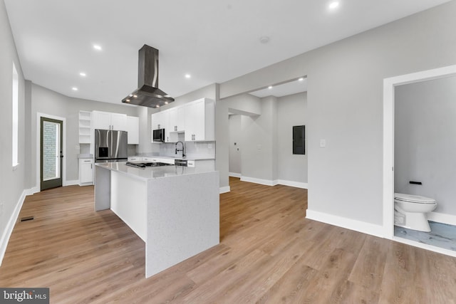 kitchen with appliances with stainless steel finishes, electric panel, white cabinets, baseboards, and light wood-style flooring