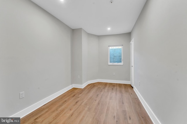 empty room with light wood-style floors, baseboards, and recessed lighting