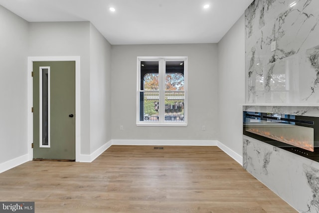 unfurnished dining area with recessed lighting, light wood-style flooring, and baseboards