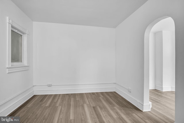 19 Valley St, Lewistown, PA 17044 - spare room featuring arched walkways, wood finished floors, and baseboards