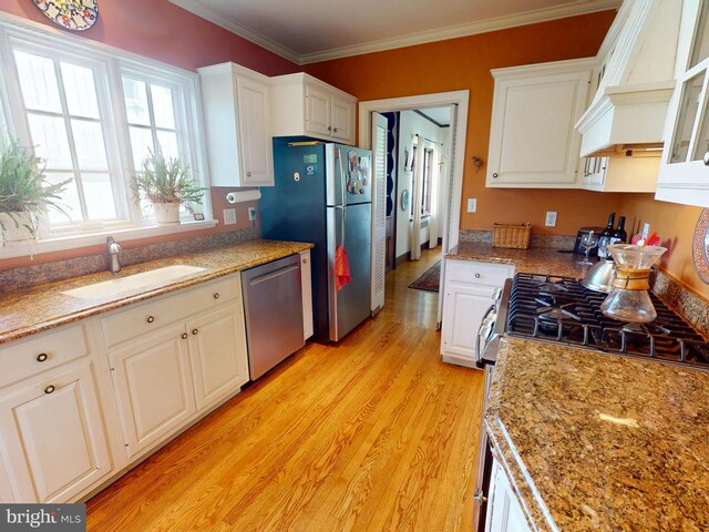 439 W Park Ave, State College, PA 16803 - kitchen featuring stainless steel appliances, a sink, premium range hood, white cabinets, and ornamental molding