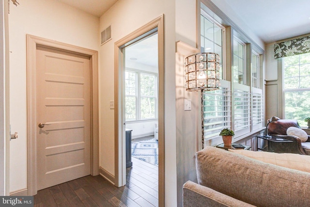 doorway to outside featuring dark wood finished floors, a chandelier, and baseboards