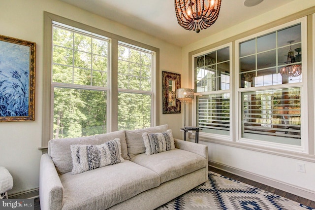 living room with a chandelier, baseboards, and wood finished floors