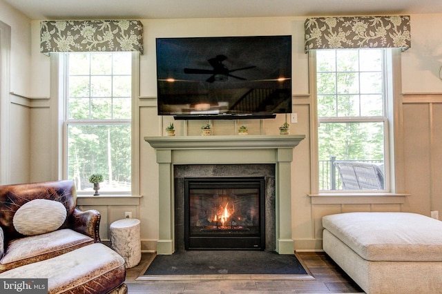 bedroom with a fireplace with flush hearth, wood finished floors, and multiple windows