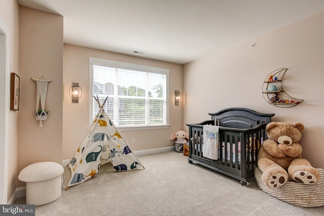 carpeted bedroom with baseboards and a nursery area