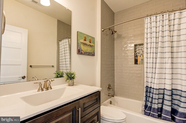 bathroom with shower / bathtub combination with curtain, vanity, and toilet