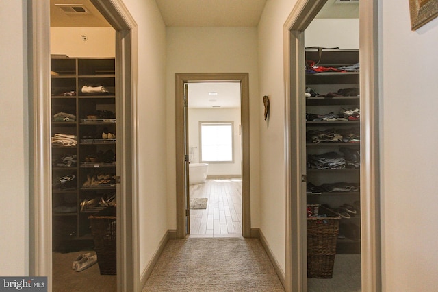 hallway featuring carpet flooring and baseboards