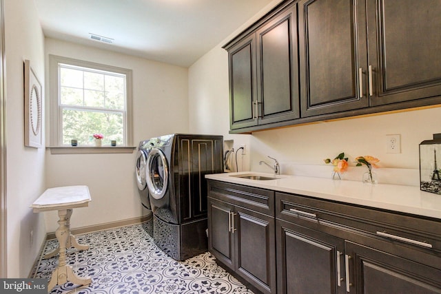 laundry room featuring cabinet space, baseboards, independent washer and dryer, and light tile patterned floors