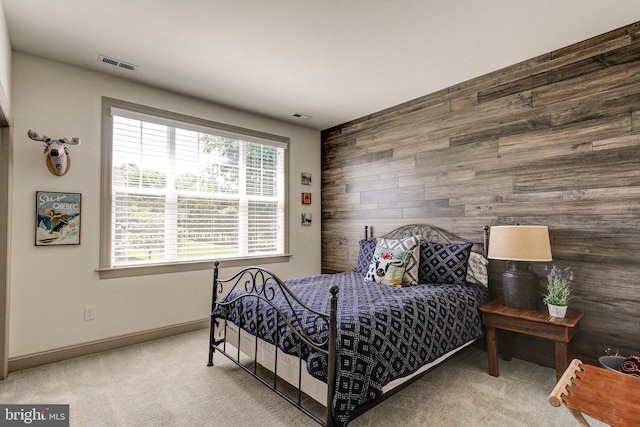 bedroom with carpet floors, baseboards, and wooden walls