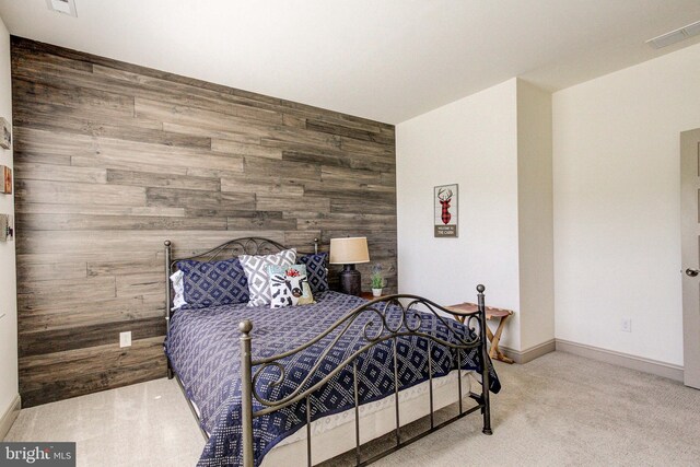 bedroom featuring wood walls, carpet floors, and baseboards