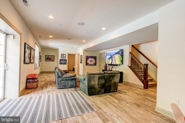 living area featuring light wood-style floors, stairs, recessed lighting, and baseboards