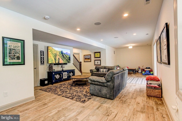 living area featuring light wood-style flooring, stairs, recessed lighting, and baseboards