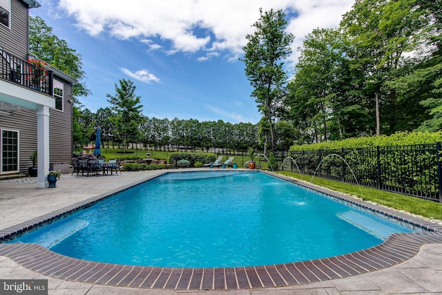 view of pool featuring a patio, a fenced backyard, and view of wooded area