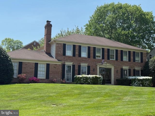 9100 Hunting Horn Ln, Potomac, MD 20854 - colonial house with a chimney, a front lawn, and brick siding