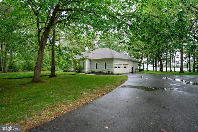 8320 Ingleton Cir W, Easton, MD 21601 - view of property exterior featuring asphalt driveway, a yard, an attached garage, and a chimney