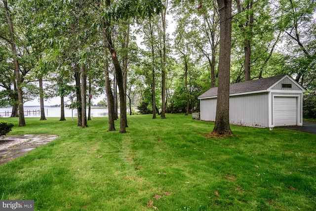 8320 Ingleton Cir W, Easton, MD 21601 - view of green lawn featuring an outdoor structure, a water view, a garage, and asphalt driveway