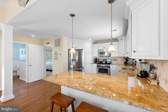 127 E 13th St, Long Beach Township, NJ 08008 - kitchen featuring stainless steel appliances, a sink, a peninsula, decorative columns, and decorative backsplash