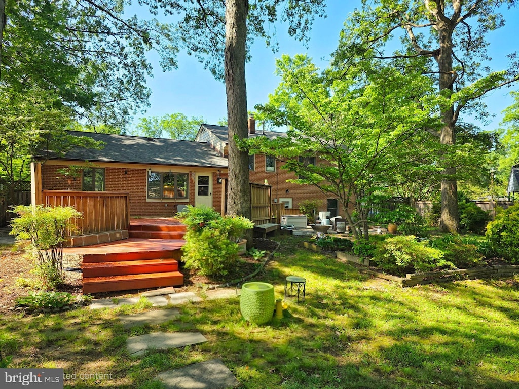 rear view of house featuring a wooden deck and brick siding