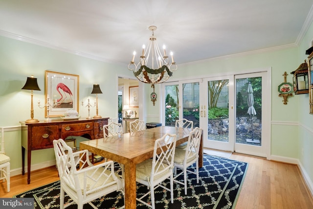 dining area with a chandelier, light wood-type flooring, plenty of natural light, and crown molding