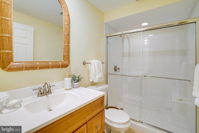bathroom featuring toilet, a stall shower, vanity, and recessed lighting
