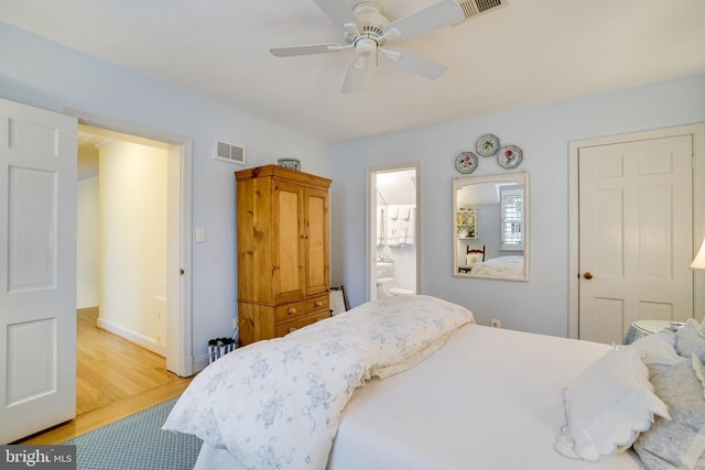 bedroom with wood finished floors, ensuite bathroom, baseboards, and ceiling fan