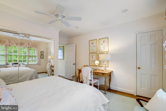 bedroom featuring crown molding, wood finished floors, baseboards, and a ceiling fan