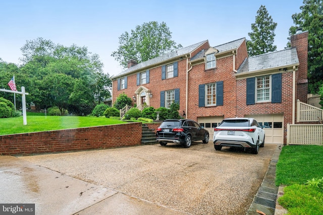 view of front of property featuring a chimney, concrete driveway, brick siding, a garage, and a front yard