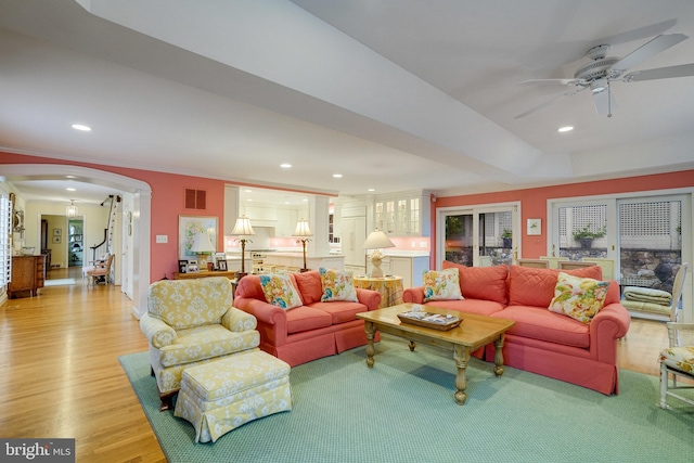 living room featuring wood finished floors, arched walkways, ceiling fan, recessed lighting, and ornate columns