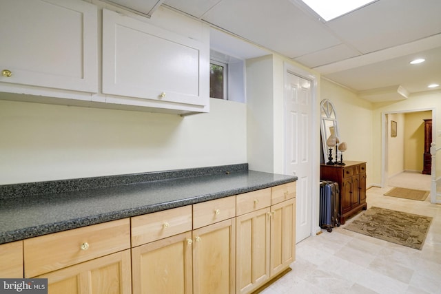 kitchen featuring radiator heating unit, dark countertops, light brown cabinetry, and recessed lighting