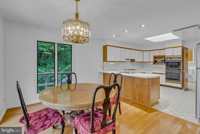 109 Kingfisher Cir, Weems, VA 22576 - dining area with a skylight, a chandelier, light wood-style flooring, and recessed lighting