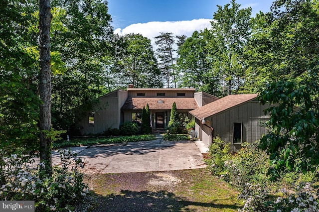 109 Kingfisher Cir, Weems, VA 22576 - rear view of property featuring driveway, a garage, a chimney, and a shingled roof
