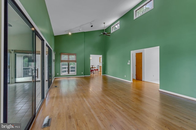 109 Kingfisher Cir, Weems, VA 22576 - unfurnished room featuring a towering ceiling, ceiling fan, rail lighting, wood finished floors, and baseboards