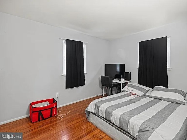 bedroom featuring wood finished floors and baseboards