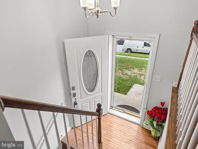 entrance foyer featuring a chandelier, wood finished floors, and stairway
