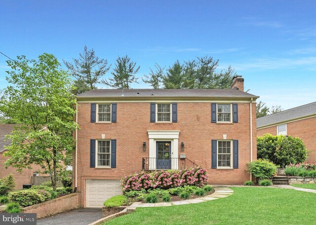 4701 Fort Sumner Dr, Bethesda, MD 20816 - colonial-style house with an attached garage, driveway, a chimney, and brick siding