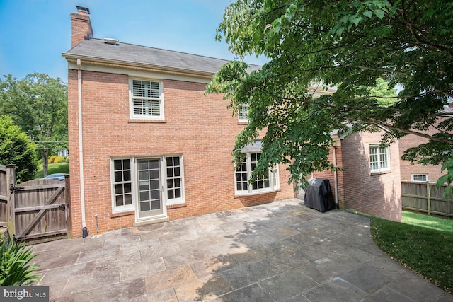 4701 Fort Sumner Dr, Bethesda, MD 20816 - rear view of house with a chimney, brick siding, a patio, and a gate