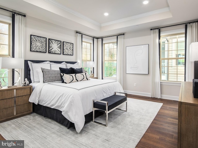bedroom with crown molding, wood finished floors, a tray ceiling, baseboards, and recessed lighting