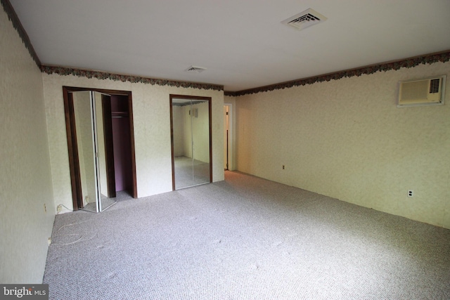 unfurnished bedroom featuring carpet flooring and two closets