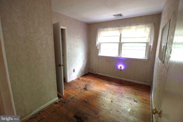 unfurnished room featuring wood-type flooring and baseboards