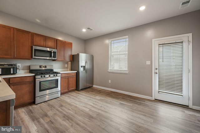 45 Quigley Ct, Camden Wyoming, DE 19934 - kitchen with stainless steel appliances, light countertops, baseboards, light wood-style flooring, and brown cabinets