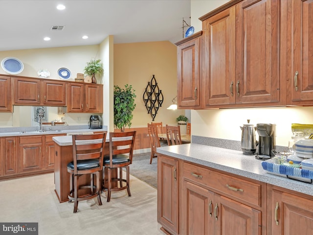 7705 Forney Way, Harrisburg, PA 17112 - kitchen with light countertops, a sink, brown cabinets, vaulted ceiling, and a kitchen bar
